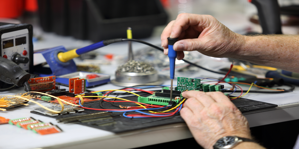 a person using a soldering iron to connect wires